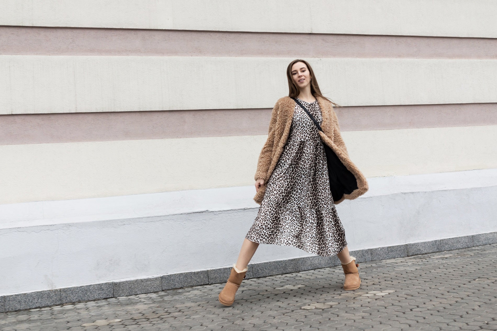 Person frolicking in the street wearing Ugg boots sold by Boot World