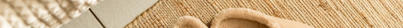 Pair of Ugg slippers at the foot of a bed