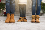 Winter photo of family wearing boots int he snow